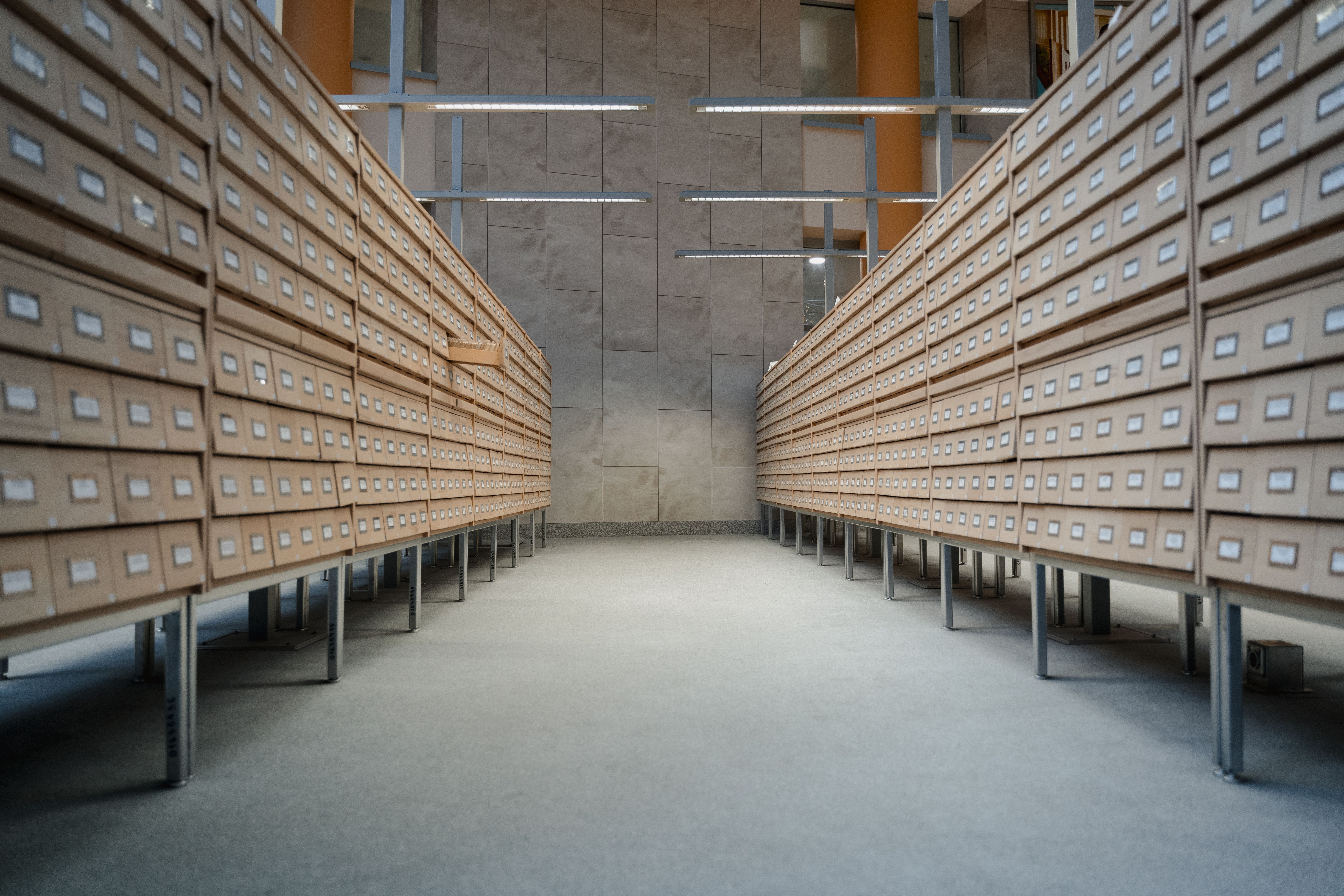 Rows of wooden archive drawers in a library, illustrating organized document preservation and records management.